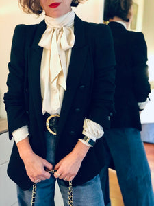 Aude, créatrice de la boutique Ôdette curated vintage porte une blouse en soie Yves Saint Laurent avec col lavallière. 